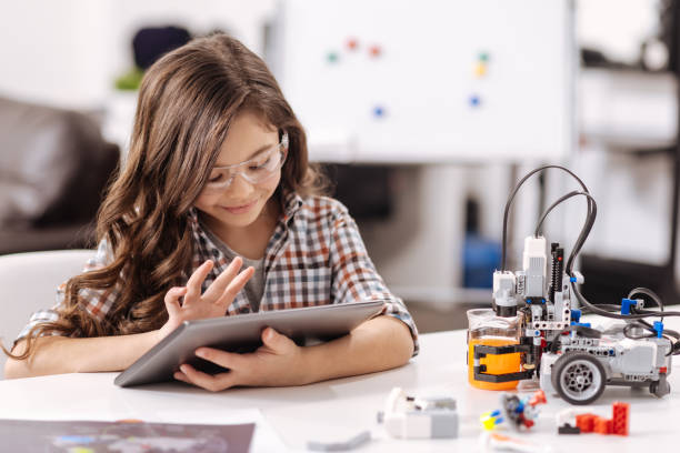 istock Amused teen girl using tablet in the science studio 653948436
