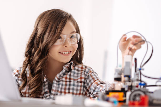istock Smiling girl expressing positive emotions in the science studio 653948654