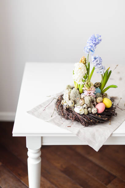 istock Flower arrangement in a nest with easter eggs on a white table 653949382