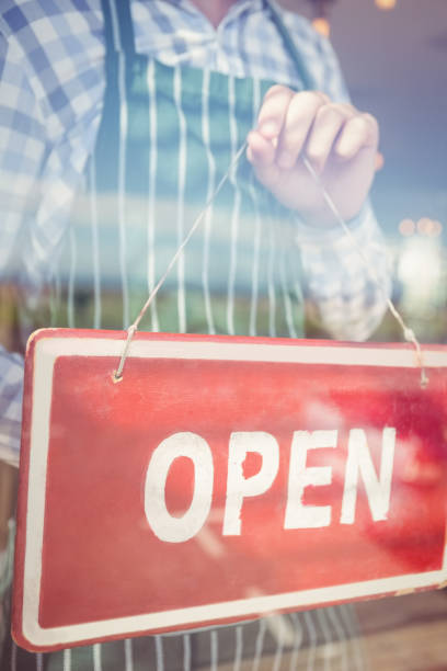 istock Waiter holding open signboard 653949808