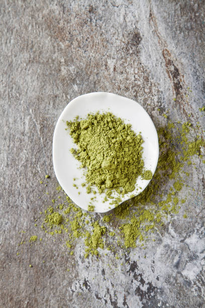 istock Matcha tea on a small white plate. Gray background. Top view 653950730