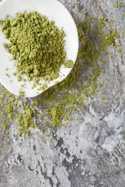 istock Matcha tea on a small white plate. Gray background. Top view 653950742