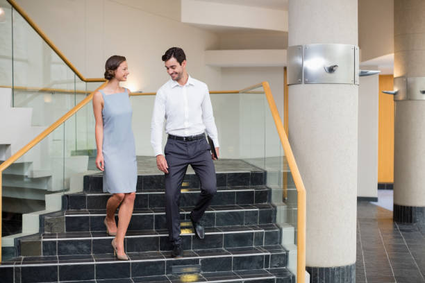 istock Business executives moving down steps at conference centre 653951198