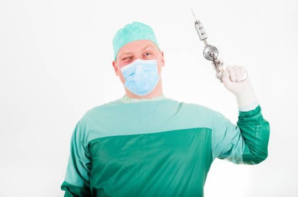 istock Surgeon holding antique, old fashioned medical drill on white background 653955264