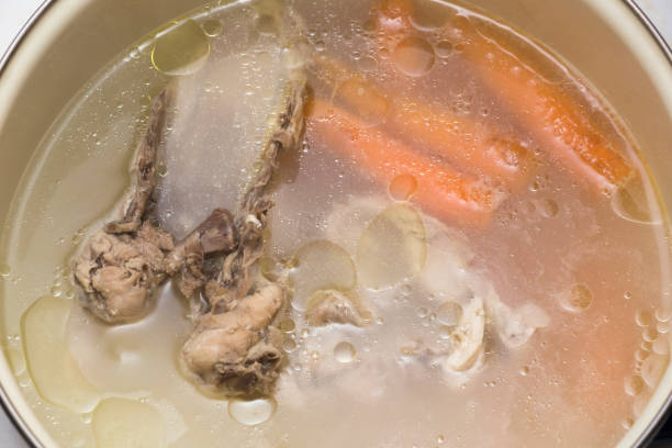 cocinar sopa con carne y verduras en una olla. vista de ángulo alto. - cooking domestic kitchen vegetable soup fotografías e imágenes de stock