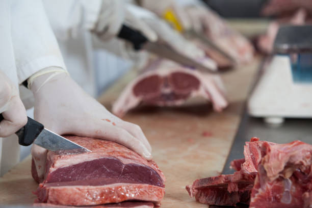 istock Butcher cutting meat at meat factory 653962018
