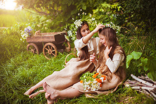 Beautiful little girls in a white dress posing in the grass
