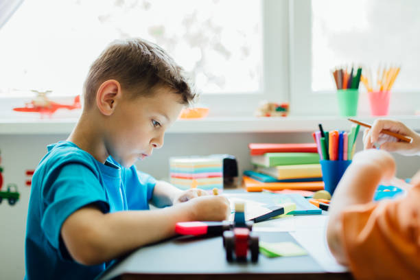 istock Side view of a whistling student doing his homework 653962898