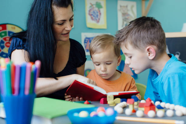 istock Mother reading a book to her children 653963280
