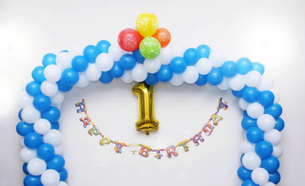 First birthday, anniversaey decoration on white wall stock photo