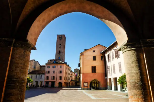 Piazza Risorgimento, main square of Alba (Piedmont, Italy) seen through the colonnade of Saint Lawrence Cathedral