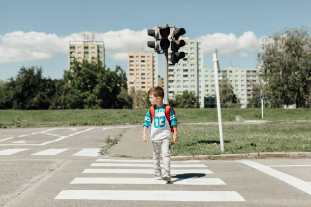 Schoolboy crossing a road on his morning way to school stock photo