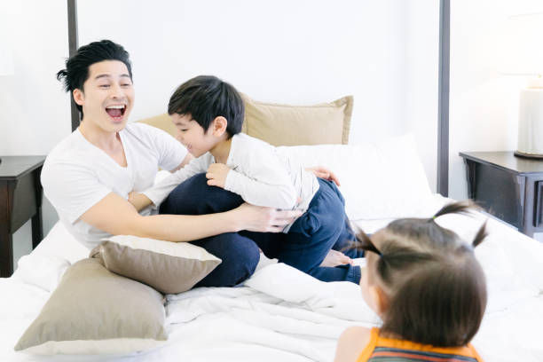 istock Father playing with baby son and daughter on bed 653968882