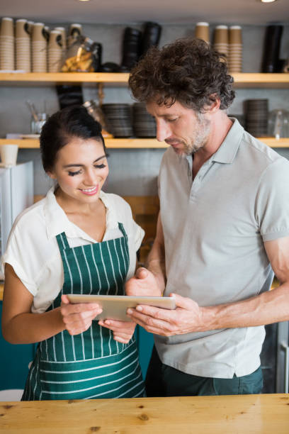 istock Waiter and waitress discussing over digital tablet 653970004