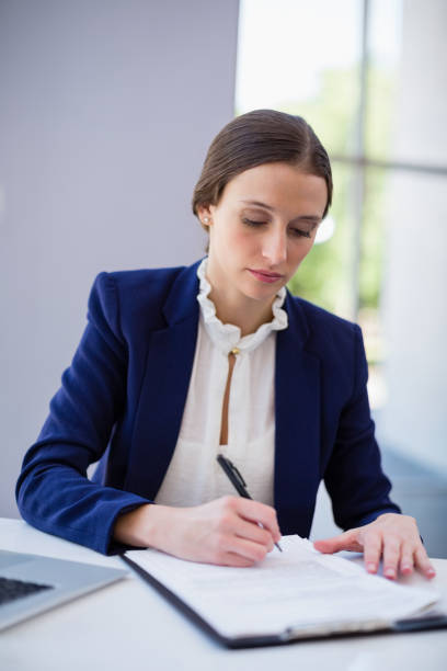 istock Businesswoman writing on clipboard 653974268