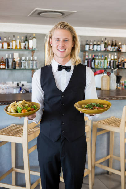 istock Waiter holding plated meals in restaurant 653975062