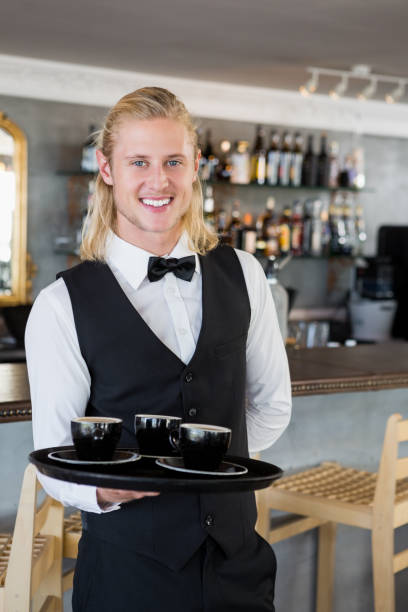 istock Waiter holding a tray with coffee cups in restaurant 653975142