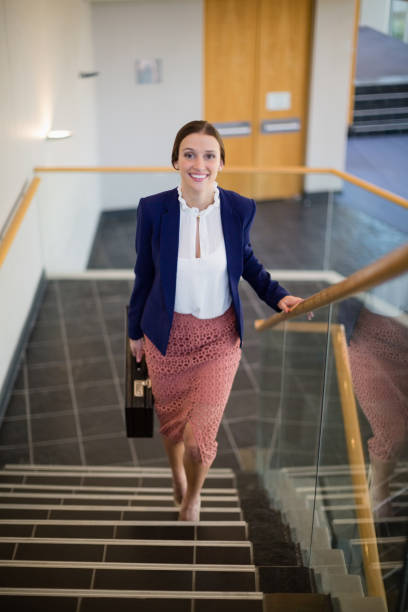 istock Businesswoman carrying briefcase climbing steps 653978712