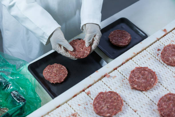 istock Butcher arranging hamburger patty on tray 653978770