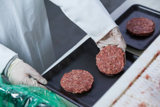 istock Butcher arranging hamburger patty on tray 653978826