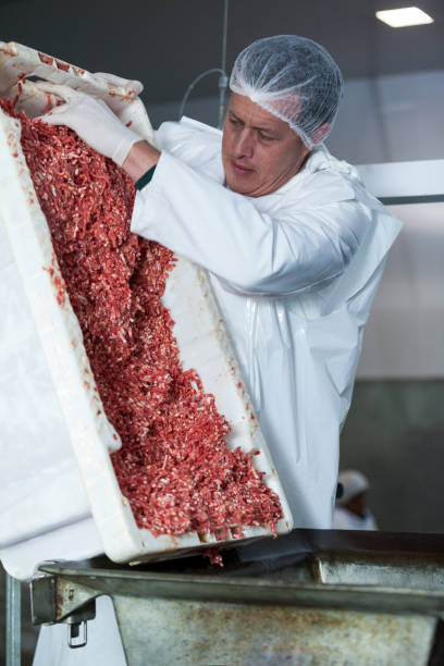 istock Butcher emptying tray with minced meat 653979488