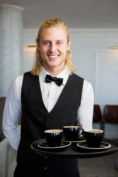 istock Waiter holding a tray with coffee cups in restaurant 653981838