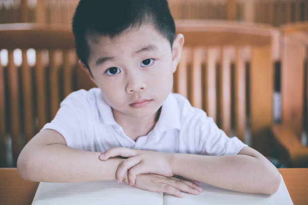 istock Cute boy contemplating in classroom 653982090