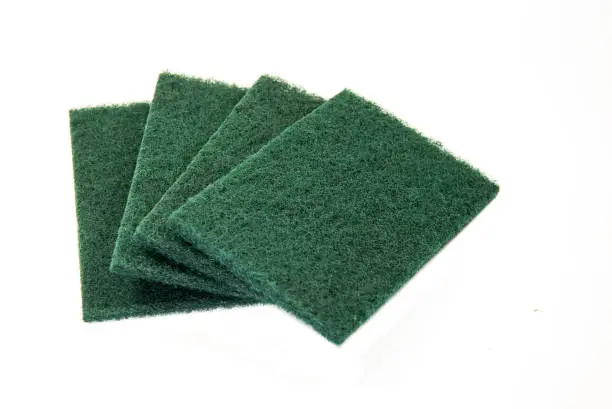 Green scouring pads on white background, selective focusing