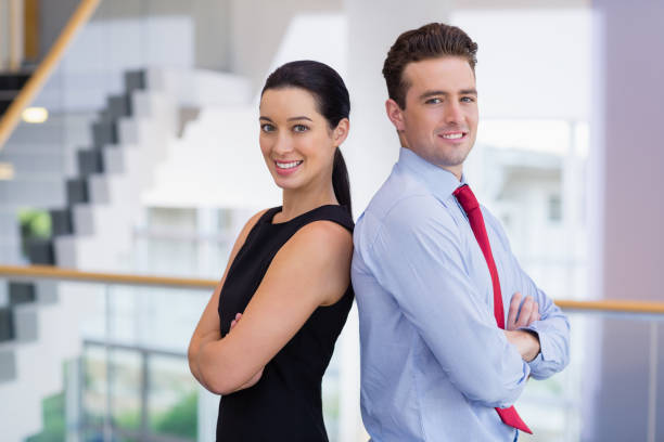 ejecutivos de negocios seguros de pie espalda con espalda con los brazos cruzados - two people back to back businesswoman women fotografías e imágenes de stock