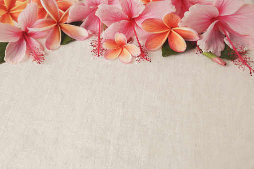 Frangipani, Plumeria, Hibiscus flowers on linen, copy space background, selective focus, vintage tone