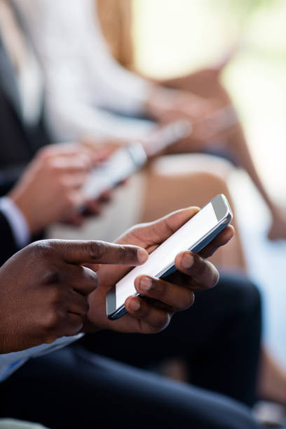 istock Close-up of business executives using mobile phone 654017046
