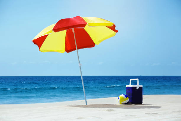 leerer strand mit sonnenschirm meer münzensammeln - strandschirm stock-fotos und bilder