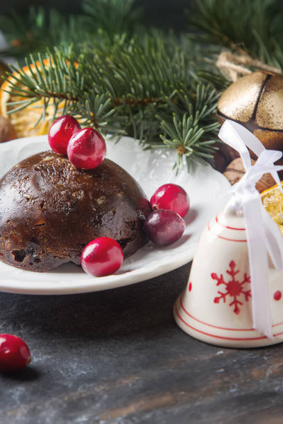 istock Christmas chocolate pudding with cranberries, walnuts, cinnamon, apples and oranges. Dark background. 654034888