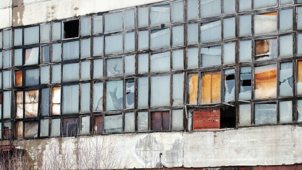 istock Exterior with broken windows of an old industrial building 654035220