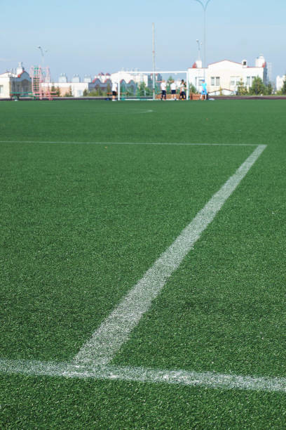 istock Football field with artificial green surface and marking lines. Focus on foreground 654041788
