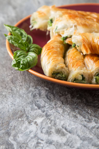 istock Traditional homemade Greek cheese, spinach pie on a red plate. G 654044510