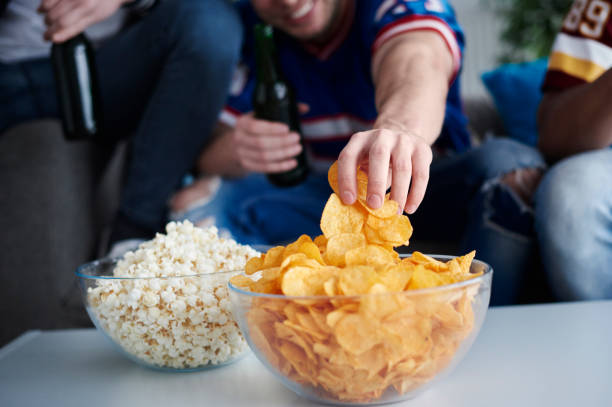 nahaufnahme des herren hand packte chips - zwischenmahlzeit stock-fotos und bilder