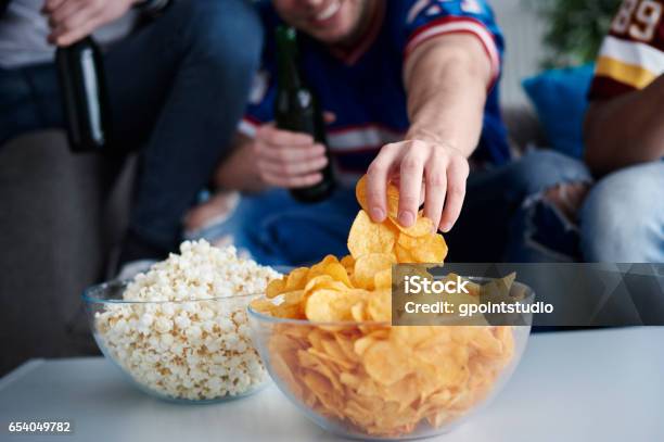 Close Up Of Mens Hand Grabbing Chips Stock Photo - Download Image Now - Eating, Potato Chip, Snack