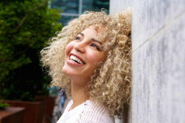 istock Happy young woman leaning on wall 654054642