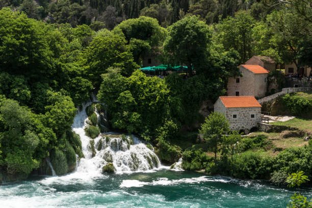 una vista panorámica sobre el río, cascada y casas de los viejos en el parque nacional de krka. - run of the mill fotografías e imágenes de stock