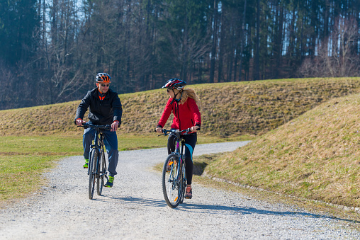 Couple Cycling Through Countryside Together