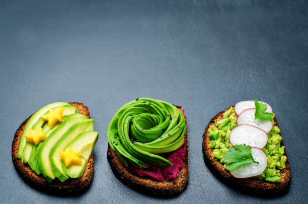 Variation of healthy rye breakfast sandwiches with avocado and toppings