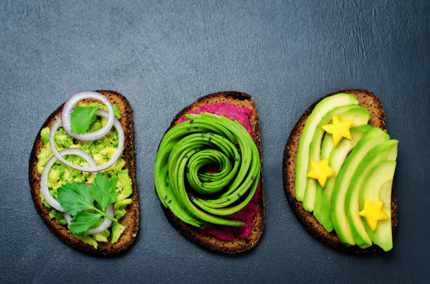 Variation of healthy rye breakfast sandwiches with avocado and toppings