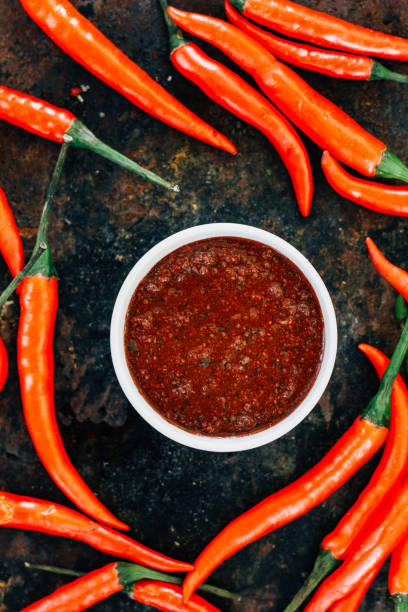 istock Red mexican salsa surrounded by red hot chili peppers. 654062466