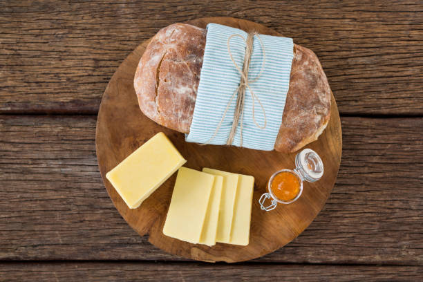 Slices of cheese and bread on wooden board