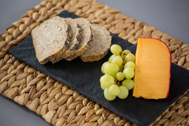 istock Gouda cheese, bread slices and grapes on slate plate 654062892