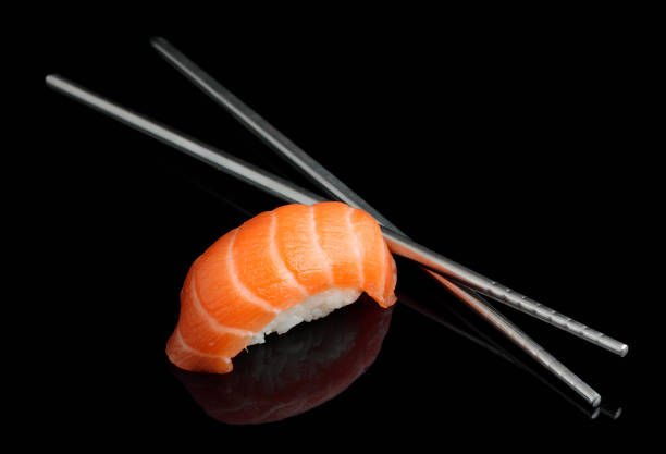 istock Sushi with chopsticks on black background 654067598