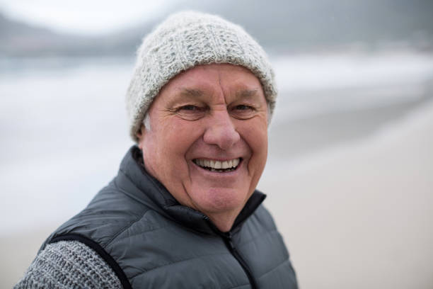 istock Portrait of senior man standing on the beach 654069082