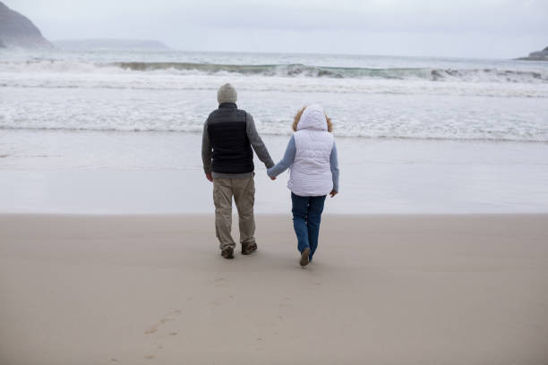 istock Senior couple walking together on the beach 654069252