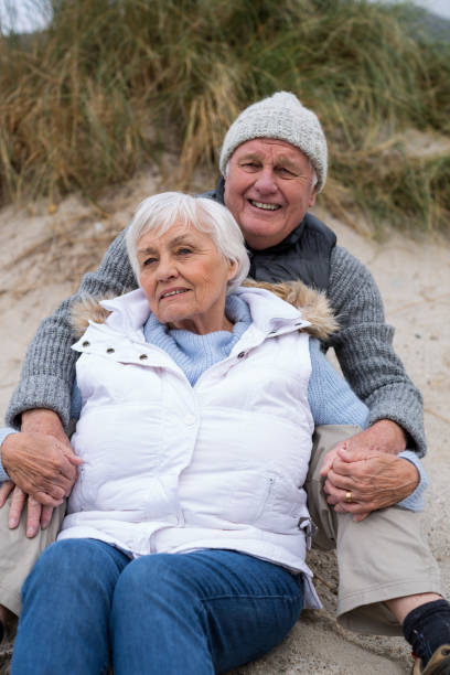 istock Senior couple sitting together on beach 654069470